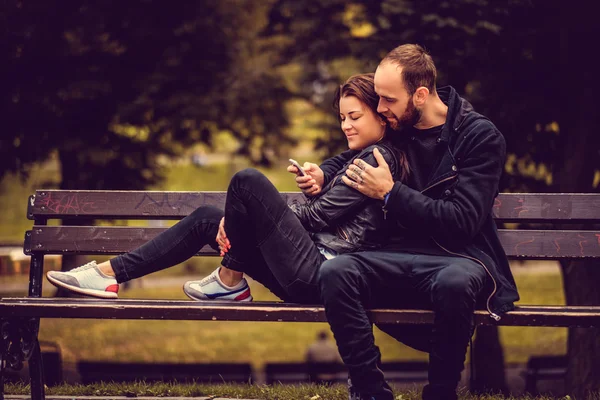 Pareja cariñosa posando en un banco — Foto de Stock