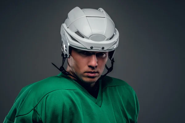 Portrait of hockey player on grey background. — Stock Photo, Image