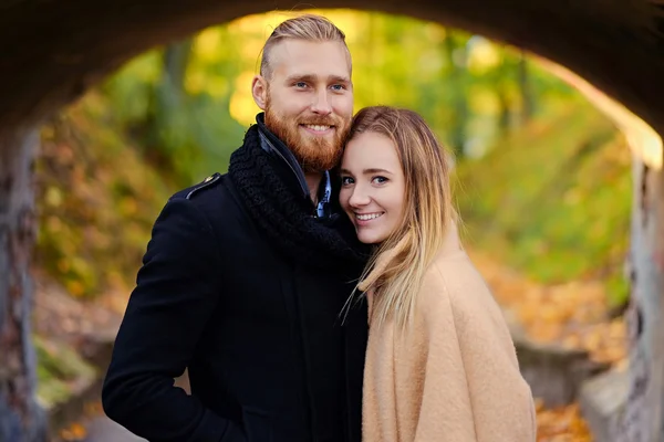 Redhead bearded male hugs blonde female