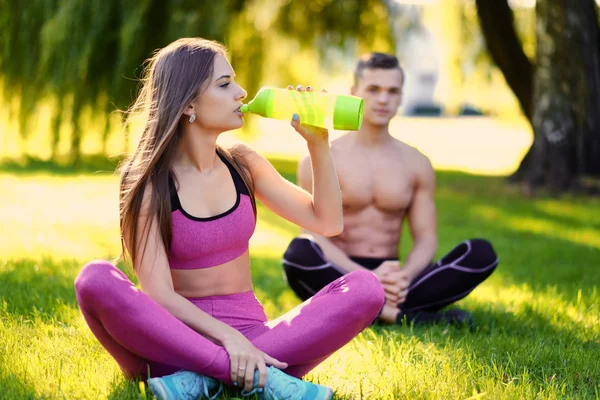 Junges sportliches Paar entspannt im Gras — Stockfoto