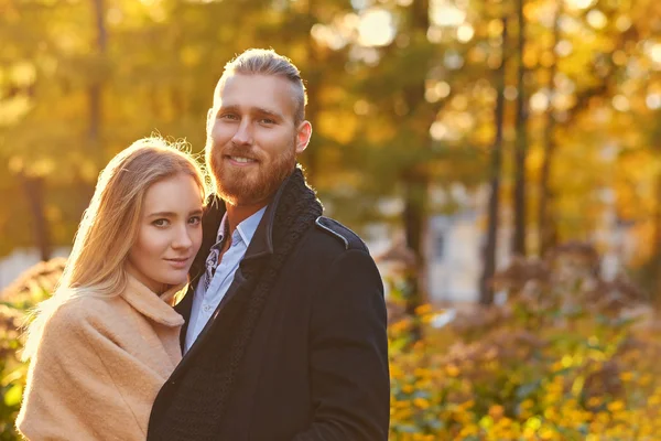 Redhead bearded male hugs blonde female