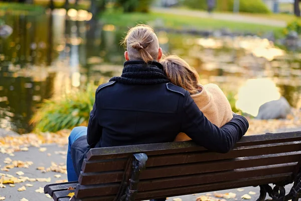 Casal sentado no banco no parque de outono — Fotografia de Stock