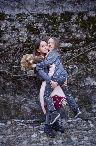 Dziewczyna trzyma jej siostra w ramionach. — Zdjęcie stockowe