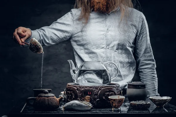 Positive bearded male pours hot water — Stock Photo, Image