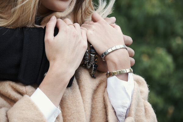 Мужские и женские руки с браслетами
