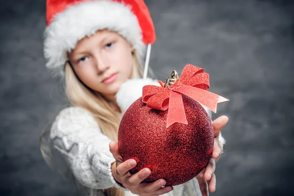 Meisje houdt rode kerst bal — Stockfoto