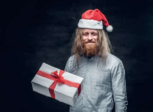 Homem de chapéu de Papai Noel segura caixa presente . — Fotografia de Stock