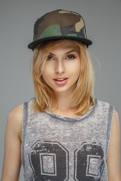 Positive blonde girl in military cap.