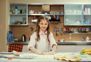 Positive little girl making dough clipart