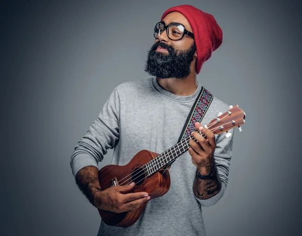 Barbuto hipster maschio giocare su ukulele — Foto Stock