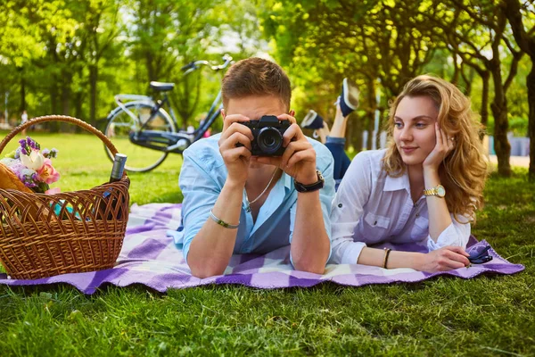 Pareja usando una cámara fotográfica compacta en un picnic . — Foto de Stock