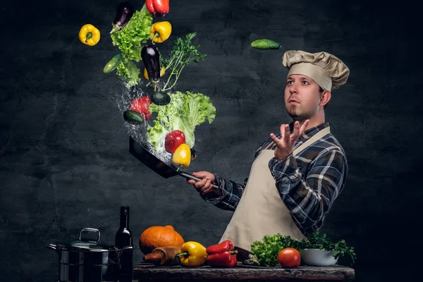 Chef with vegetables flying in the  air.