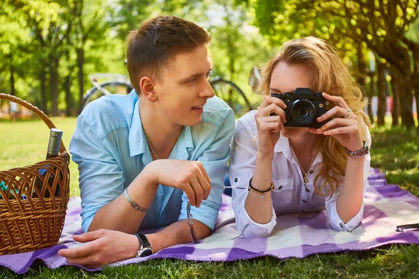 Pareja usando una cámara fotográfica compacta en un picnic . — Foto de Stock