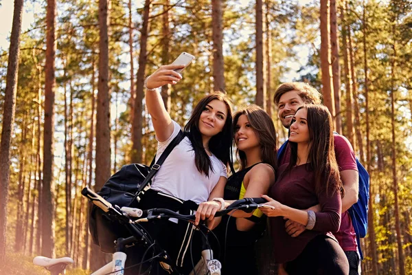 Chicas sonrientes y chico haciendo selfie — Foto de Stock