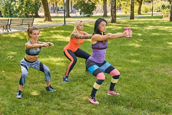 Tre donne sportive che fanno squat — Foto Stock
