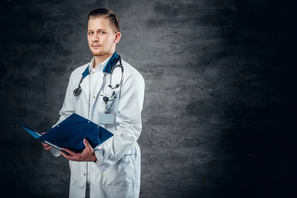Doctor sosteniendo portapapeles azul —  Fotos de Stock