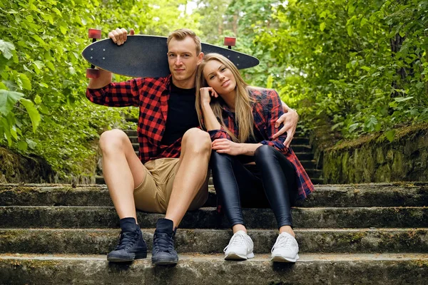 Paar entspannt sich nach Longboard-Fahrt auf den Stufen. — Stockfoto