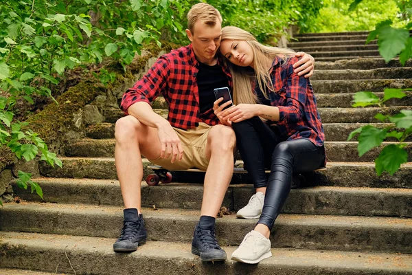 Urban couple relaxing on the steps in park — Stock Photo, Image