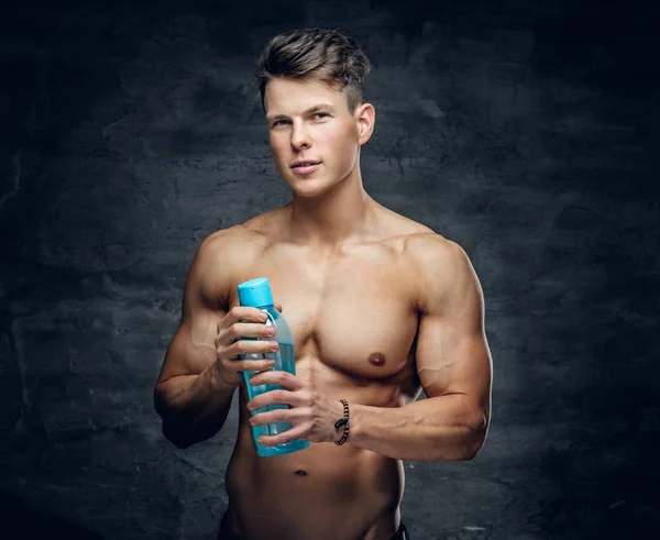 Sporty uomo tiene una bottiglia d'acqua . — Foto Stock