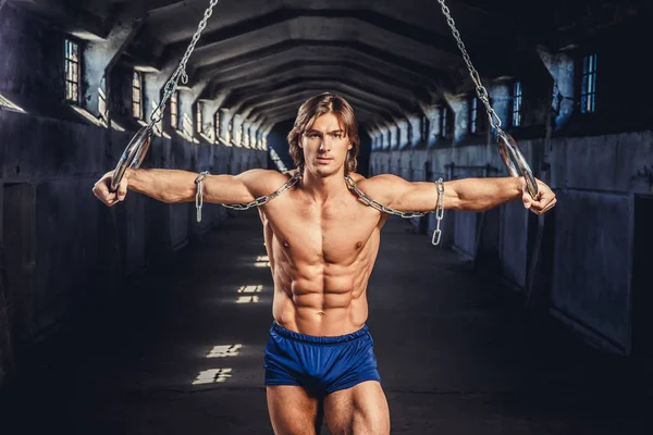 Homem muscular posando com anéis de ginástica — Fotografia de Stock