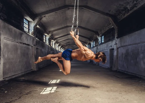 Gespierde man poseren met gymnastiek ringen — Stockfoto