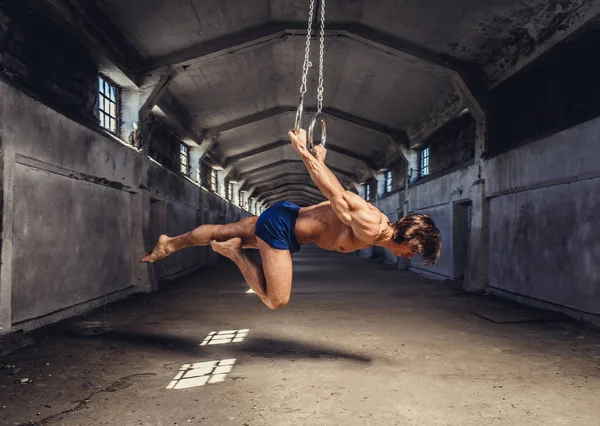 Homem muscular posando com anéis de ginástica — Fotografia de Stock