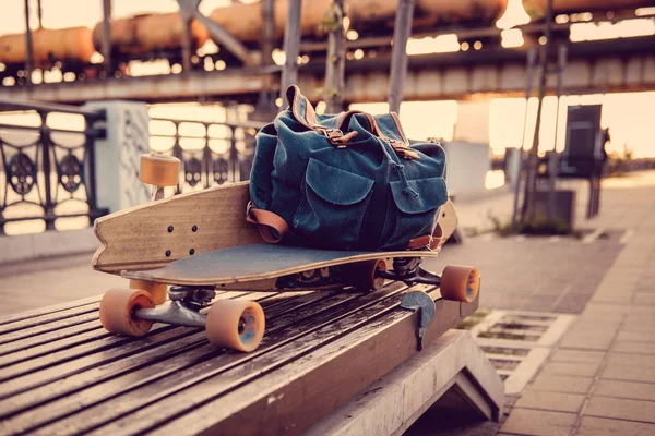 Longboard and backpack on a bench. — Stock Photo, Image