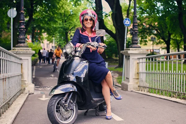 Donna in abito seduto su uno scooter moto — Foto Stock