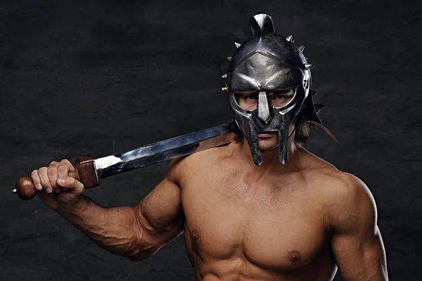 Muscular man holds an iron sword — Stock Photo, Image