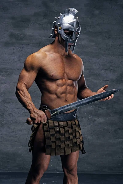 Muskulöser Mann mit silbernem Gladiatorenhelm — Stockfoto