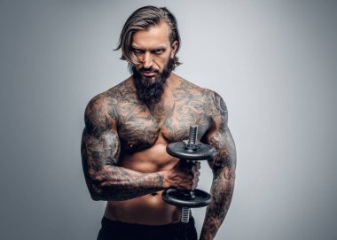 Dövmeli adam dumbbell tutar