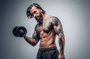 Dövmeli adam dumbbell tutar