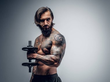 Dövmeli adam dumbbell tutar