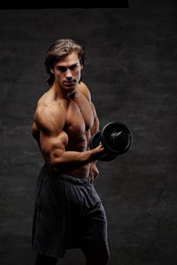 Gömleksiz karın erkek dumbbell tutar.