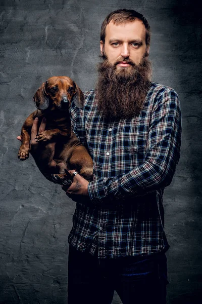 Homme barbu tenant un chien blaireau — Photo