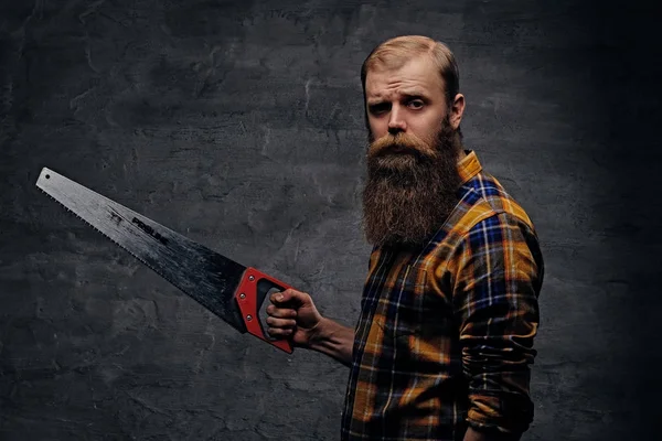 Bearded carpenter man holding handsaw. — Stock Photo, Image