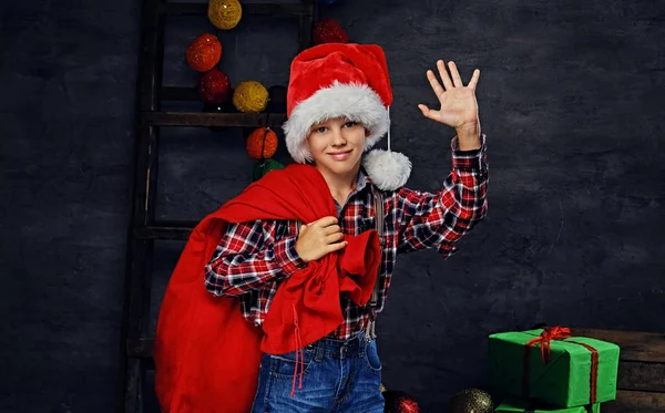 Junge im Weihnachtsmannkostüm mit roter Tasche — Stockfoto