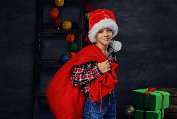 Мальчик в костюме Санты с красной сумкой — стоковое фото