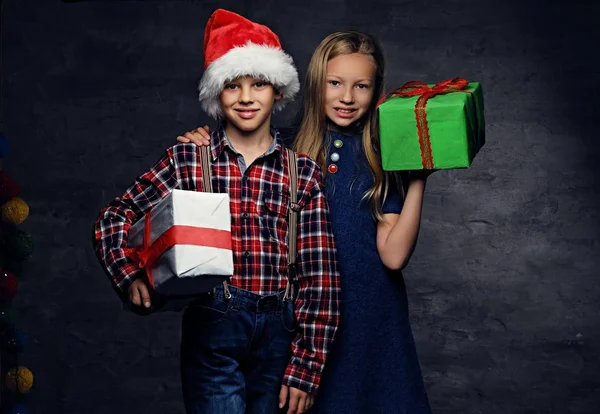 Menino e menina segurando caixas de presente — Fotografia de Stock