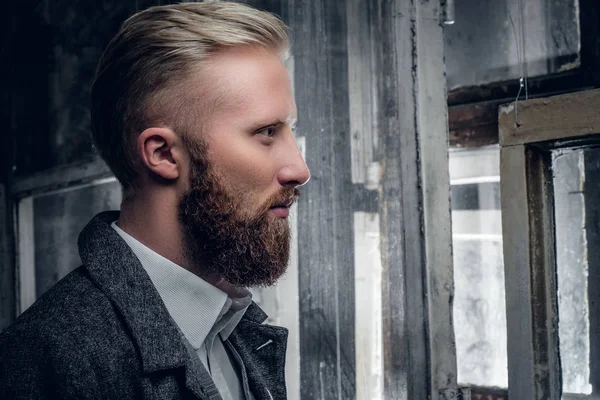 Bärtiger Mann, der aus dem Fenster schaut — Stockfoto