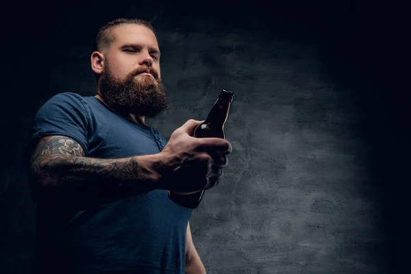 Hombre barbudo mirando la botella de cerveza — Foto de Stock