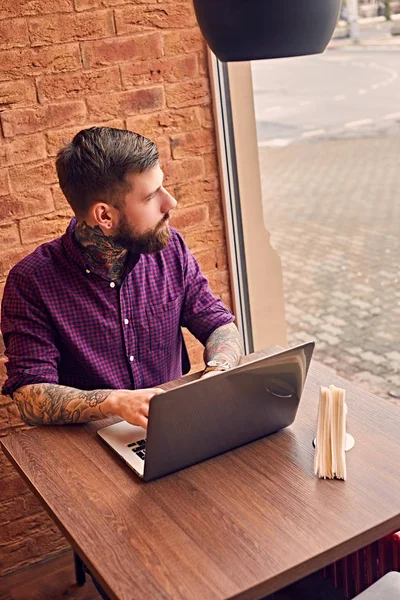 Bearded hipster with tattooed arms relaxing — Stock Photo, Image