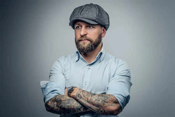 Man in a white shirt and a tweed cap