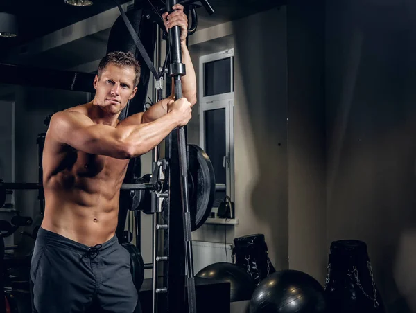 Muskulöser Mann posiert mit Langhantel — Stockfoto