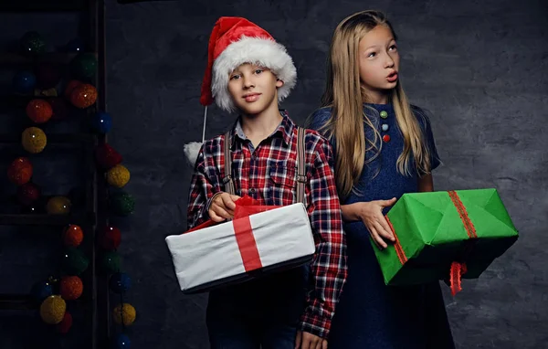 Menino e menina segurando caixas de presente — Fotografia de Stock