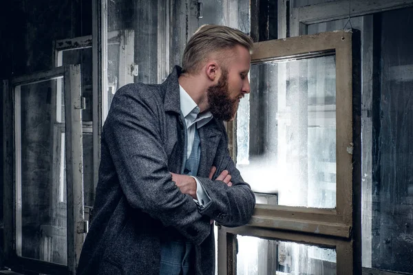 Hombre barbudo mirando a través de viejas ventanas — Foto de Stock