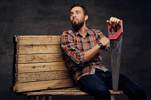 Bearded carpenter in a jeans and a plaid shirt — Stock Photo, Image