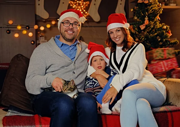 Eltern und Sohn mit Weihnachtsmannmütze — Stockfoto