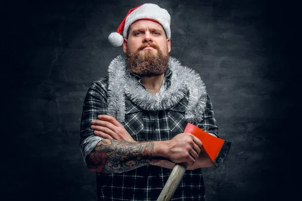 Mann mit Weihnachtsmannhut hält Axt in der Hand — Stockfoto
