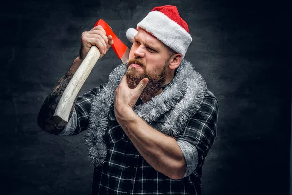 Mann mit Weihnachtsmannhut hält Axt in der Hand — Stockfoto